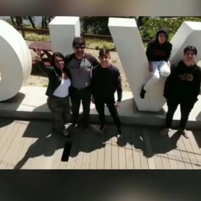 Família reunida em frente às letras gigantes da cidade de Valdivia.