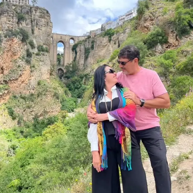 O casal abraçados diante do desfiladeiro e da ponte de Ronda.