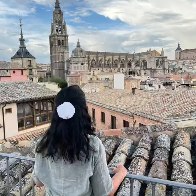 Viajante de costas olhando os telhados de Toledo e a catedral.