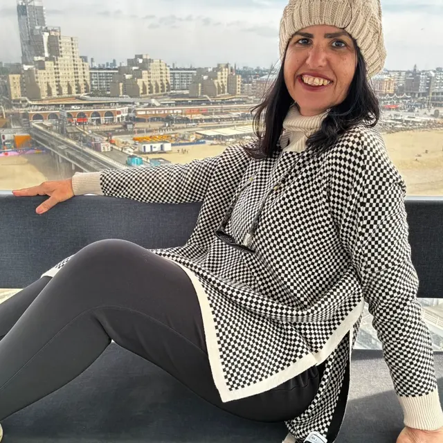 Viajante sorrindo sentada no píer de Scheveningen, em Haia.