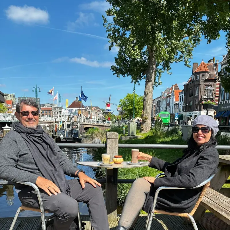 Casal tomando café numa mesa à beira do canal em Leiden.