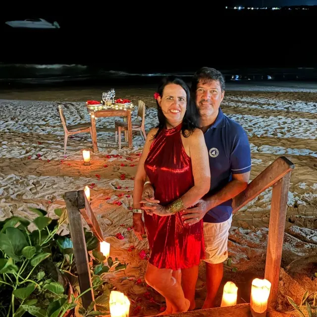 O casal num jantar romântico à luz de velas na praia de Japaratinga.