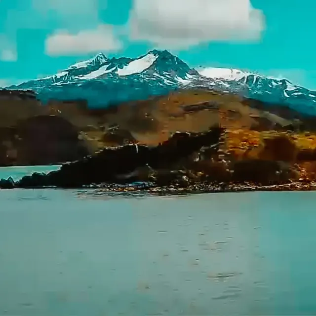 Lago turquesa e montanhas da Patagônia sob o céu azul.